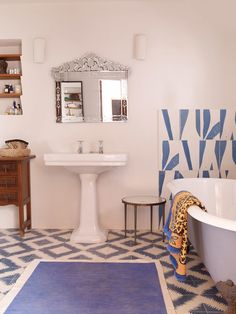 a bath room with a tub a sink and a mirror on the wall in it