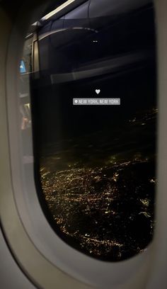 an airplane window looking out at the city lights