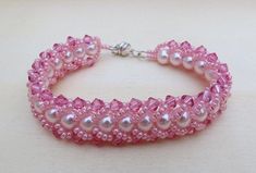 "The elegant color of pink combine with an accent of AB rose pink makes the bracelet a sweet delicate with a little bit of dazzle for your wrist. This bracelet is hand stitch using colored Czech glass pearls, swarovski bicone crystal and embellished the edge with Japanese seed beads to make a chain. The bead work is done in flat spiral style. I use the fireline beading thread to stitch and silver tone magnetic clasp to finished it off and for an easy wear. The bracelet measures 7 1/4\" and will Pink Beaded Round Pearl Bracelet, Handmade Pink Crystal Elegant Bracelet, Handmade Elegant Pink Crystal Bracelet, Pink Jubilee Bracelet With Round Beads, Elegant Adjustable Pink Bracelet, Elegant Handmade Pink Crystal Bracelet, Pink Jubilee Beaded Bracelet Gift, Handmade Pink Crystal Bangle Bracelet, Handmade Pink Crystal Round Bracelet