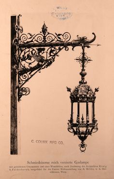 an old fashioned lamp hanging from the side of a building with wrought iron work on it