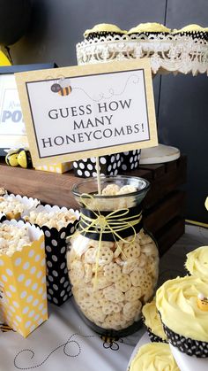 a table topped with lots of cupcakes covered in yellow frosting