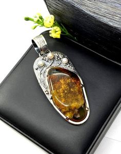 Artisan Amber with pearls pendant  Hand-made Sterling Silver 925.  Stones used: Baltic Cognac Amber, Pearls.  Height -3 2/16” (with bail), Width – 1 3/16”  Height – 80mm, width-30mm.Unique Handcrafted One-of a-kind Design PendantEach Piece of Jewelry in my Collection is Absolutely One of a Kind!When you start wearing a piece of my jewelry you will fall in love with it more and more each day and feel that good Energy and Love that I pass into it while creating this piece of Art.A piece of Art cre Cheap Oxidized Pendant Jewelry, Elegant Amber Jewelry With Large Pendant, Artisan Sterling Silver Pearl Pendant Jewelry, Artisan Sterling Silver Jewelry With Pearl Pendant, Artisan Amber Jewelry With Cabochon Detail, Artisan Amber Jewelry With Cabochon, Elegant Amber Rectangular Pendant Jewelry, Luxury Amber Pendant Jewelry, Unique Amber Jewelry With Engraving