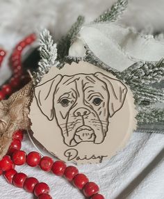 an ornament with a dog's face on it next to red beads