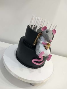 a cake with a mouse on top and forks sticking out of it's back