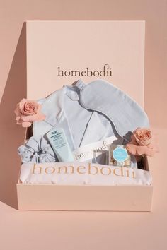 the homebodii gift box is packed with baby clothes, body lotion and flowers