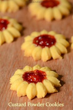 small cookies with jam on them sitting on a table