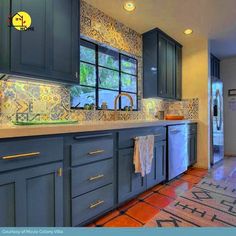 a kitchen with blue cabinets and tile flooring