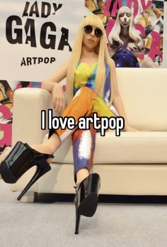 a woman sitting on top of a couch next to a white chair with the words i love artpop