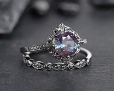 an engagement ring with a blue topazte surrounded by white diamonds and filigrees