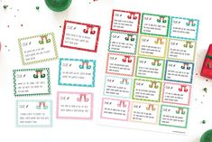 some christmas themed printables are on the table next to green balls and other holiday decorations