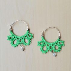 These delicate earrings were made by shuttle tatting directly onto 20mm ear wires using Scheepjees Sugar Rush mercerized cotton thread in Spring Green. Small metal beads keep the thread from sliding off the hoops, and small glass beads add a fun dangle element. (Original pattern) Green Macrame Earrings As A Gift, Green Macrame Earrings For Gift, Green Macrame Dangle Earrings, Green Bohemian Hoop Earrings Hypoallergenic, Bohemian Green Hoop Earrings Hypoallergenic, Handmade Adjustable Green Hoop Earrings, Adjustable Handmade Green Hoop Earrings, Bohemian Green Hypoallergenic Hoop Earrings, Shuttle Tatting