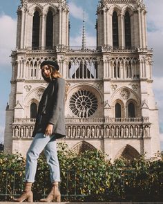 a woman standing in front of a large cathedral