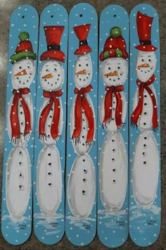 four snowmen are painted on the back of their skateboards with red hats and scarfs