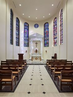 an empty church with stained glass windows and pews