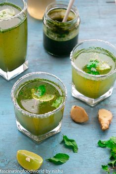 three glasses filled with green drinks and garnished with mint