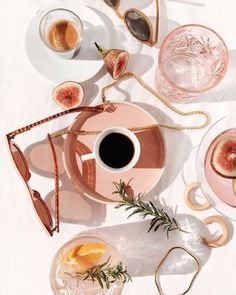 a table topped with plates and cups filled with food next to glasses on top of each other