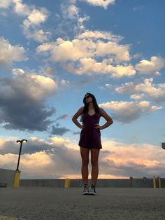 a woman standing in the middle of an empty parking lot