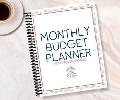 a notebook with the title month - by - month budget planner next to a cup of coffee