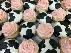 a box filled with cupcakes covered in frosting and pink icing on top of each other