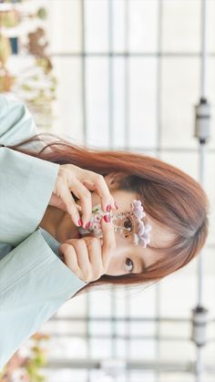 a woman with long red hair and flowers in her hair is talking on the phone