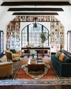 a living room filled with lots of furniture and bookshelves covered in bookcases