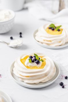 two white plates topped with desserts on top of a table