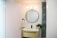 a bathroom with a sink and mirror next to a door that leads to another room