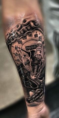 a man's arm with a clock and engine tattoo on the left side of his arm