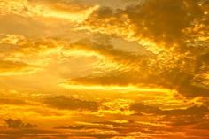 an airplane flying in the sky at sunset with clouds and sunbeams behind it