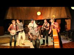 a group of people standing around each other with guitars