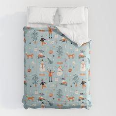 a bed covered in a blue and white comforter with snowmen, deers and trees on it