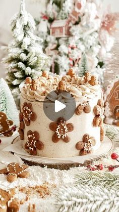 a christmas cake is decorated with cookies and icing on a table next to small trees