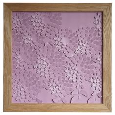 a wooden frame with paper cut flowers on it