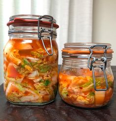 two jars filled with food sitting on top of a table