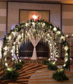 a wedding arch decorated with flowers and greenery