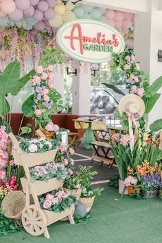 an assortment of flowers and plants are on display in front of the entrance to an outdoor cafe