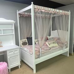 a white bed sitting in a bedroom next to a desk