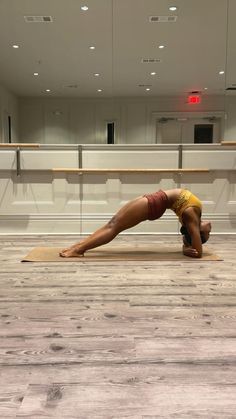 a woman doing a yoga pose in an empty room