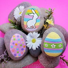 some rocks with painted easter eggs and daisies