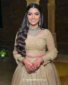 a woman in a gold dress posing for the camera