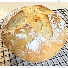 a loaf of bread sitting on top of a cooling rack with powdered sugar in it