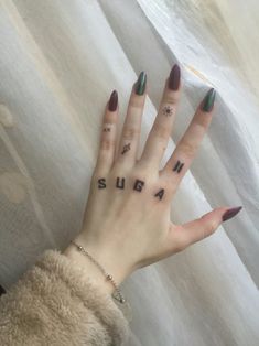 a woman's hand with the word sugar tattooed on her left thumb and fingers