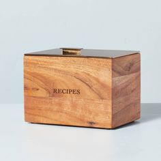 a wooden box with the word recipes written on it sitting on a white countertop