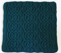 a green knitted square on top of a white surface