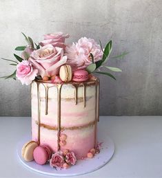 a cake decorated with pink flowers and macaroni shells is displayed on the instagram page