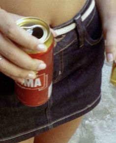 a woman is holding a can of soda