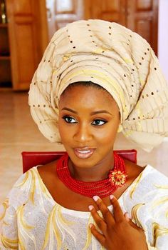 a woman wearing a white turban and red necklace