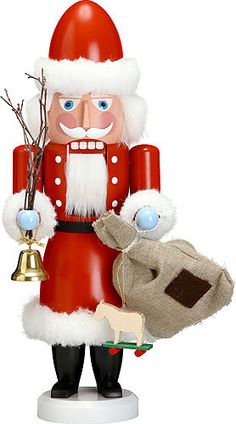 a christmas nutcracker holding a bell and tree branch with a bag on it