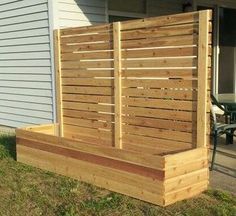 a wooden fence sitting on top of a grass covered yard next to a building with a patio