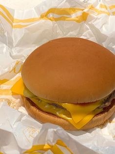 a cheeseburger with pickles and ketchup is on the wrapper